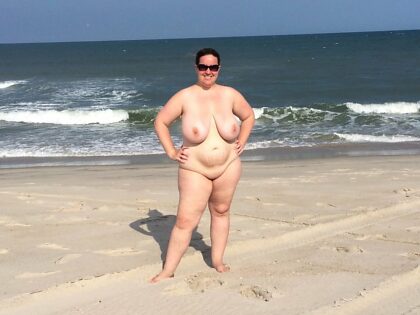 Грудастая нудистка позирует на пляже