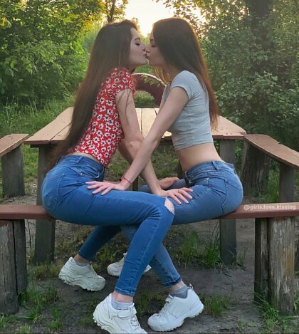 Girls sharing a kiss in the park