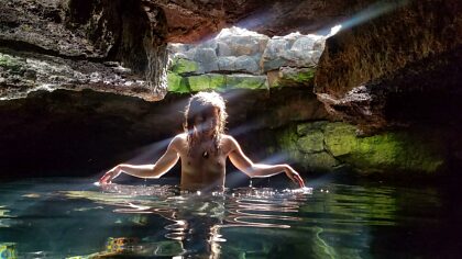 Nymph in a sacred lava tube playing with the light rays