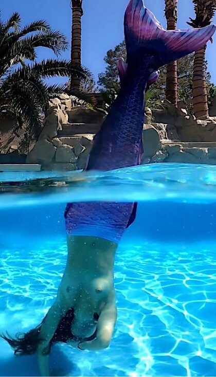 Сияющая топлесс русалка делает стойку на руках под водой